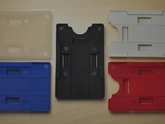 Porta-tarjetas rígidos en azul, negro, blanco y rojo sobre una mesa de madera