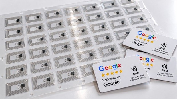 Ilustración de un pliego de antenas NFC con chip y, encima, tres tarjetas para reseñas de Google ya terminadas